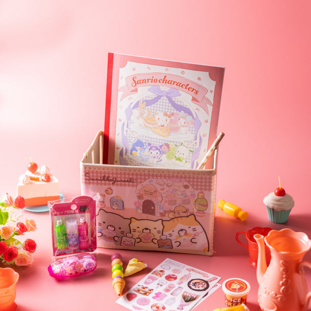 The Doki Doki Kawaii Crate by Japan Crate is displayed in a cute box, surrounded by Japanese plushies, toys, a teapot, cupcakes, flowers, and sticker sheets on a pink background.